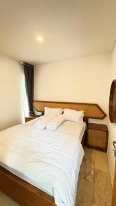 a bedroom with a large bed with white sheets and pillows at Villa Alibaba D3 in Batu +4 photos