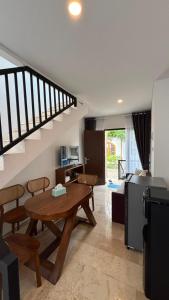 a living room with a wooden table and a kitchen at Villa Alibaba D3 in Batu