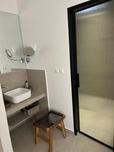 a bathroom with a shower and a sink and a stool at Villa Melita Seafront in Pefki +85 photos