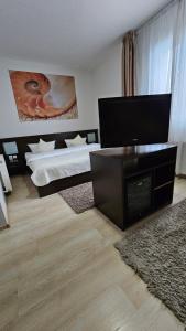 a bedroom with two beds and a flat screen tv at Hotel Poarta Transilvaniei in Bistriţa
