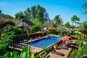 an image of a resort pool with chairs and umbrellas at Villa Khao Phaengma in Wang Nam Khieo