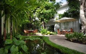 a garden with a table and chairs and a pond at The Tree - Adults only in Siem Reap