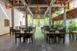 a restaurant with tables and chairs in a room at Tanei Angkor Resort and Spa in Siem Reap