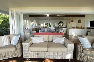 a living room with two wicker chairs and a couch at Seasons at South Mission Beach in South Mission Beach