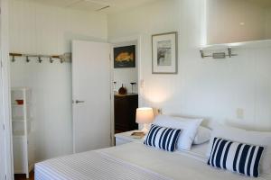 a bedroom with a white bed with blue and white pillows at Seasons at South Mission Beach in South Mission Beach