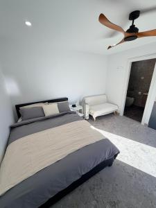 a bedroom with a bed and a ceiling fan at Sydney Studio with Private Bathroom & Kitchen in Revesby