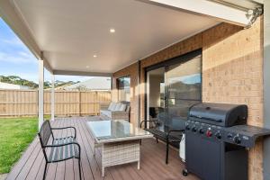 a patio with a grill and a table on a deck at Pembrey Loop Cowes in Cowes