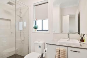 a bathroom with a toilet and a sink and a shower at Pembrey Loop Cowes in Cowes +11 photos