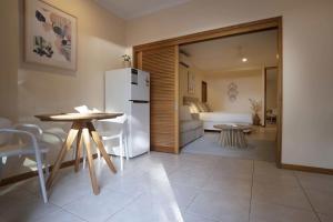 a kitchen with a refrigerator and a table and a bedroom at Latitude 17 Suite 3 in South Mission Beach