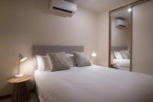a bedroom with a large white bed and a mirror at Latitude 17 Suite 4 in South Mission Beach +35 photos