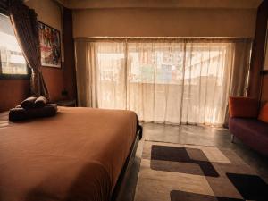 a bedroom with a bed and a window and a couch at Cinematique Boutique Cinema Hotel in Bangkok