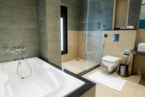a bathroom with a bath tub and a toilet at Akaya Elegance in Ahmadnagar