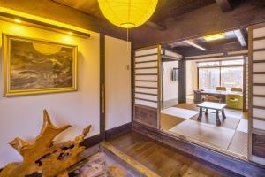 a room with a table and a tree branch on the wall at Ocean Living LA FUKU 和歌浦 一棟貸し 愛犬と泊まれる海辺の宿 in Wakayama