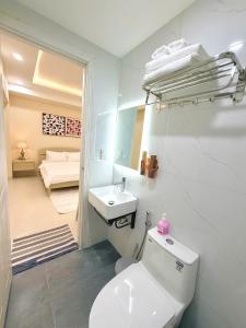 a white bathroom with a toilet and a sink at Huko House in Ho Chi Minh City +30 photos