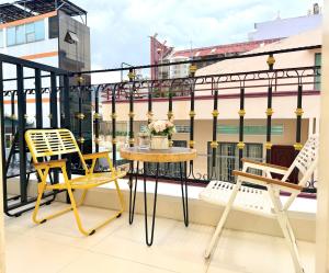 a balcony with two chairs and a table on a building at Huko House in Ho Chi Minh City