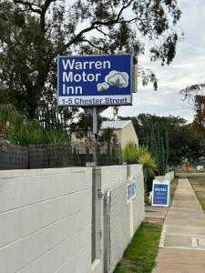 a sign for a winter motor inn on a fence at Warren Motor Inn in Warren