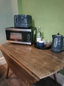 a microwave sitting on top of a wooden table at Uplands Room in Swansea