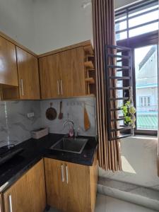 a kitchen with wooden cabinets and a sink and a window at Lishome My Khe Beach Apartment - An Thuong in Danang