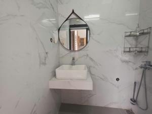a white bathroom with a sink and a mirror at Lishome My Khe Beach Apartment - An Thuong in Danang +25 photos