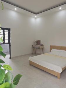 a white room with a bed and a table at Lishome My Khe Beach Apartment - An Thuong in Danang