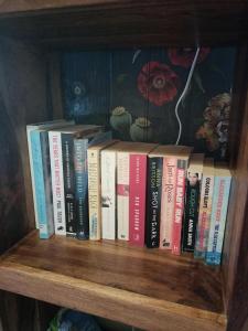 a row of books sitting on a book shelf at Uplands Room in Swansea