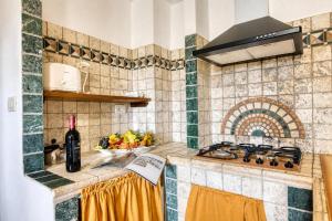a kitchen with a stove and a bowl of fruit at Tenuta Di Litiano Villa with Garden and Pool - Happy Rentals in Roccastrada