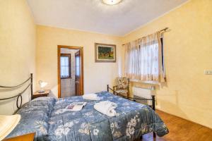 a bedroom with a bed with a blue comforter at Tenuta Di Litiano Villa with Garden and Pool - Happy Rentals in Roccastrada