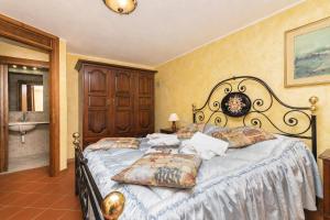 a bedroom with a large bed and a bathroom at Tenuta Di Litiano Villa with Garden and Pool - Happy Rentals in Roccastrada