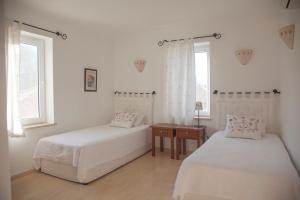 a bedroom with two beds and a table and two windows at Luxury Villa Caretta in Kaş