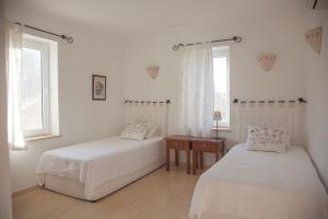 カシュにあるLuxury Villa Carettaのベッドルーム1室(ベッド2台、テーブル、窓2つ付)