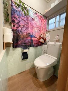 a bathroom with a toilet with a colorful towel on the wall at ヴィラ 奈良 with gift 小さなギフト付 奈良駅から15から20分 in Nara +46 photos