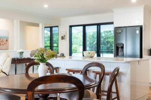 a kitchen and dining room with a table and chairs at Serenity Sands in South Mission Beach