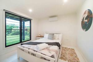 a bedroom with a bed and a large window at Serenity Sands in South Mission Beach