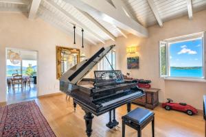 an antique piano in a living room with a view of the ocean at Paradis Relais Infinity Pool Lake View in Belgirate