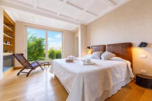 a bedroom with a large bed and a chair at Paradis Relais Infinity Pool Lake View in Belgirate