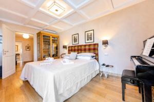 a bedroom with a large bed and a piano at Paradis Relais Infinity Pool Lake View in Belgirate