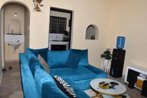 a living room with a blue couch and a table at Maya Homestay in Ukunda
