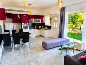 a living room with a purple couch and a kitchen at Aias Summer House in Aiándion