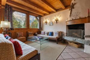 a living room with a couch and a fireplace at Chalet du Brevent ski in - ski out - Happy Rentals in Chamonix