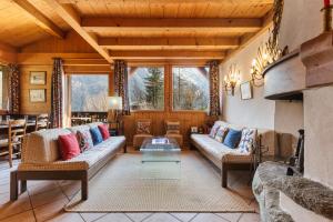 a living room with couches and a table at Chalet du Brevent ski in - ski out - Happy Rentals in Chamonix +23 photos