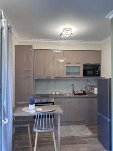 a kitchen with a table and a refrigerator at MoSta Sunset in Litochoro +15 photos