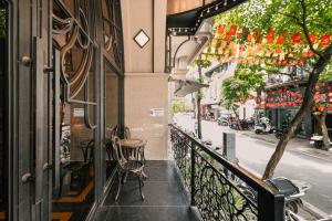 a balcony with a table and chairs on a street at Bay Luxury Fortune Grand Hotel in Hanoi