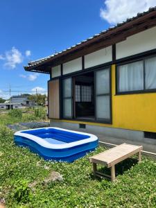 a house with a blue and white pool in the yard at よんなーハウス in Kameoka