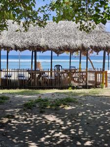 a wooden fence with tables and umbrellas on the beach at La Paraso Agatti in Agatti