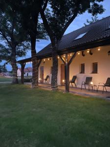 a patio with chairs under a pavilion at night at Agroturystyka u Iwony in Wiekowo