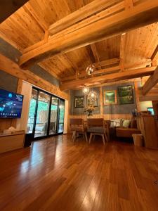 a large living room with wooden ceilings and a tv at 森権太 Forest Gonta in Takamori