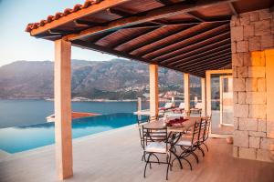 a table and chairs on a patio with a view of the water at Luxury Villa Caretta in Kaş
