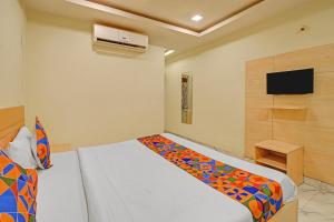 a bedroom with a bed and a tv on the wall at FabHotel Prime Nakshatra Inn in Hyderabad