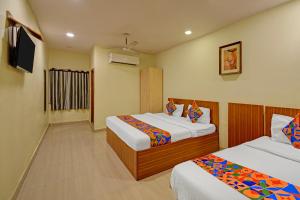 a hotel room with two beds and a television at FabHotel Prime Nakshatra Inn in Hyderabad
