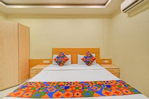 a bedroom with a bed with a colorful quilt on it at FabHotel Prime Nakshatra Inn in Hyderabad +23 photos